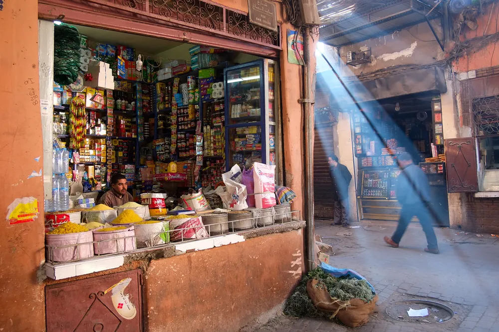 Une petite épicerie ouverte sur une ruelle de la médina, éclairée par un rayon de soleil