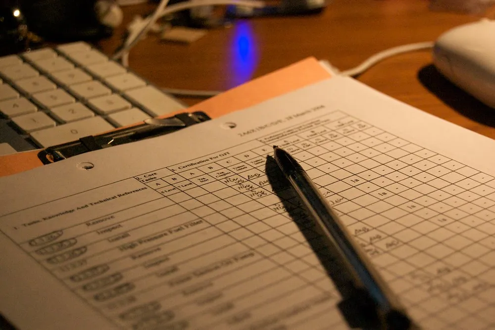Un stylo posé sur un formulaire imprimé à côté d'un clavier d'ordinateur