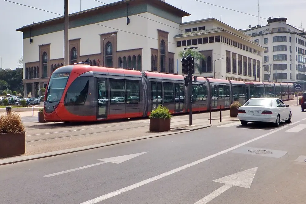 Un tramway rouge circule devant des bâtiments de style mauresque à Casablanca