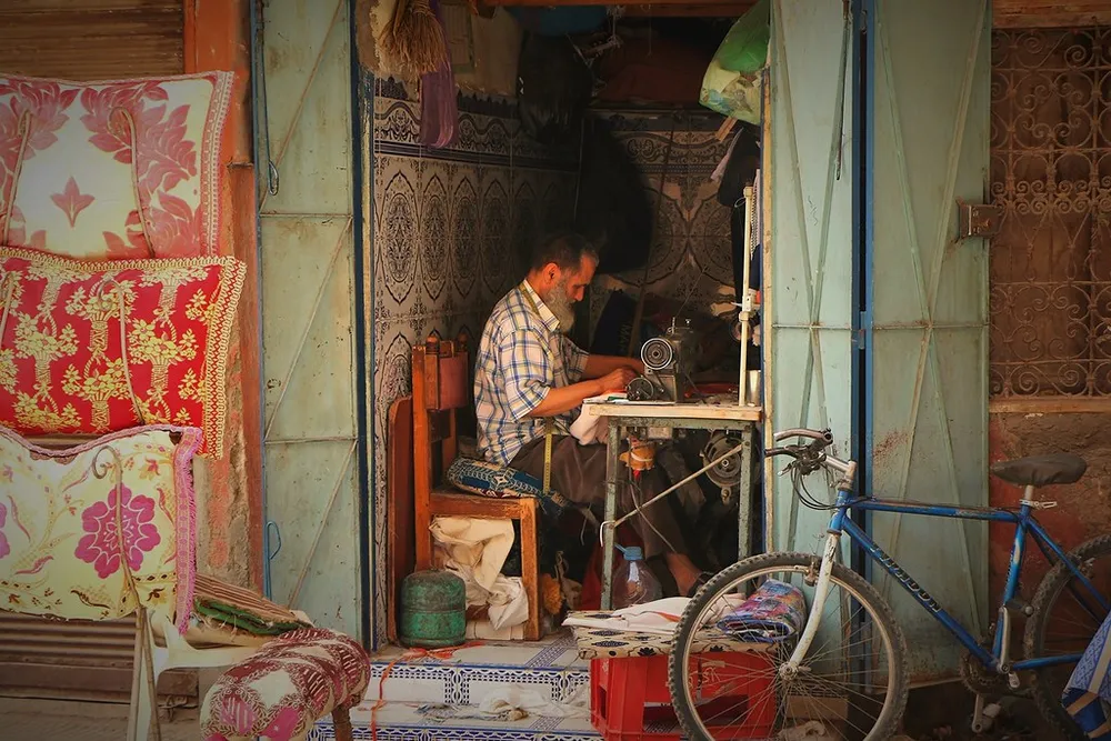 Un artisan travaille dans son petit atelier ouvert sur une ruelle de Marrakech